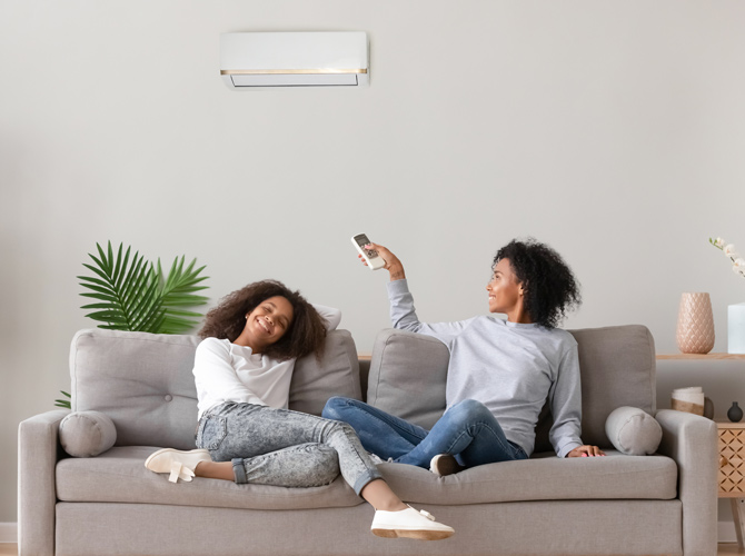 Two people enjoying their ductless heating in their living room