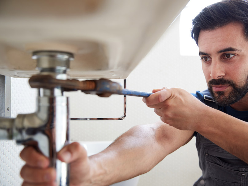 Man working on pipes of a sink