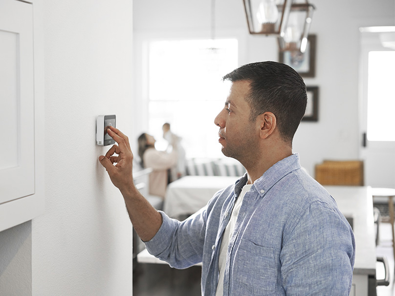 Man adjusting thermostat